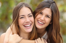 Zwei junge lachende Frauen, die sich umarmen